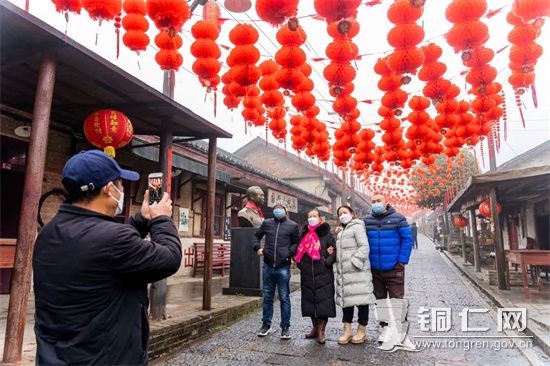 游客们在“那个年代”一条街拍照打卡，彭俊摄