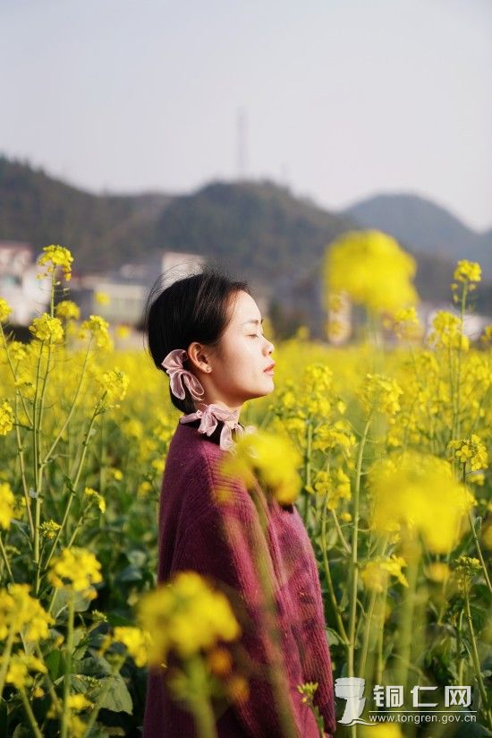 游客在油菜花田里沐浴阳光（孙磊 摄）